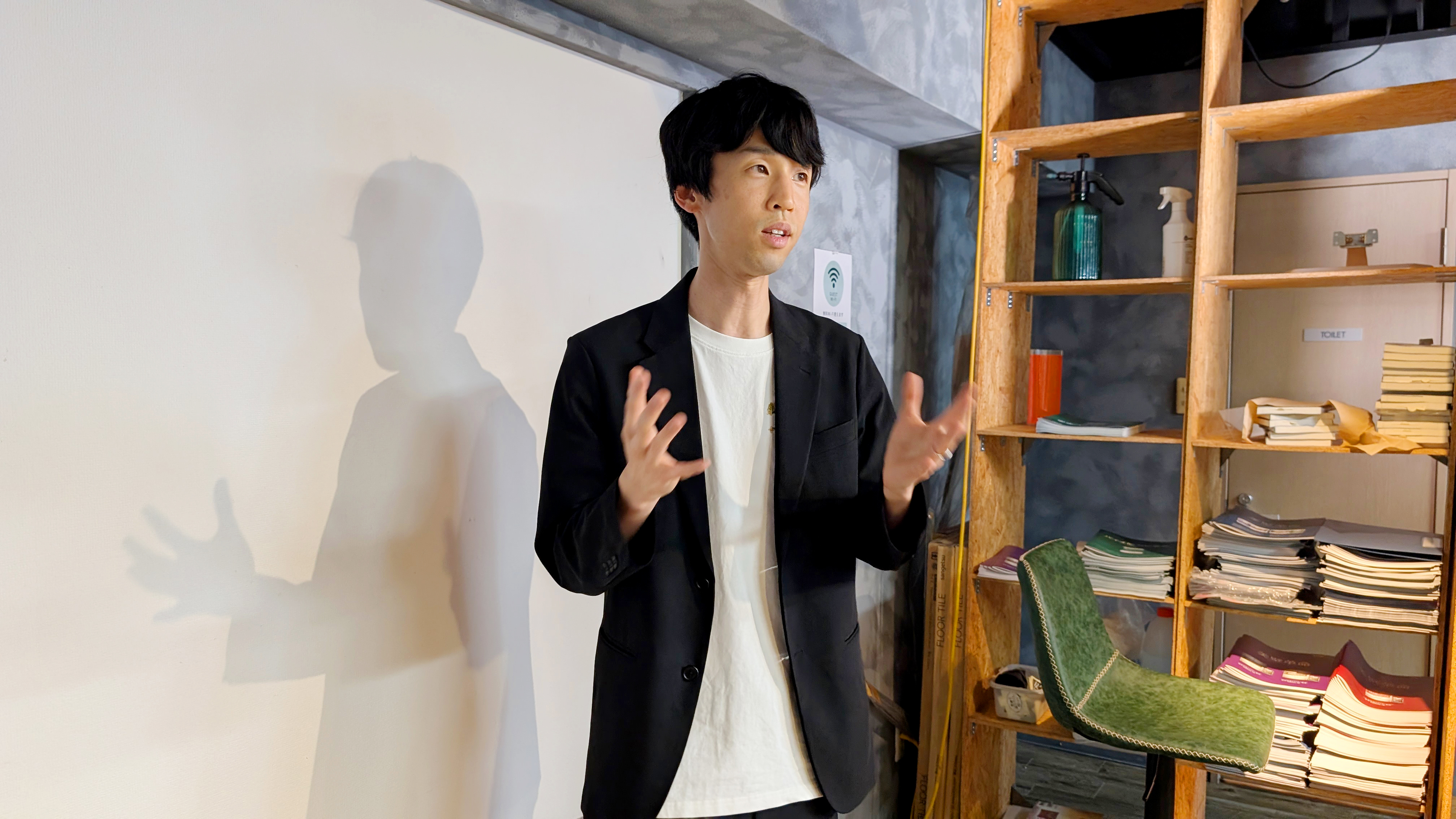 Takuya Kawai speaking and looking toward the slide text